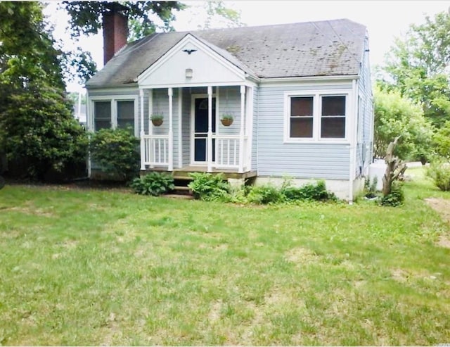 bungalow-style home with a front lawn and a chimney