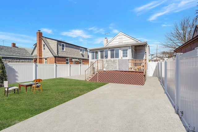 back of property with a patio area, a yard, a chimney, and a fenced backyard