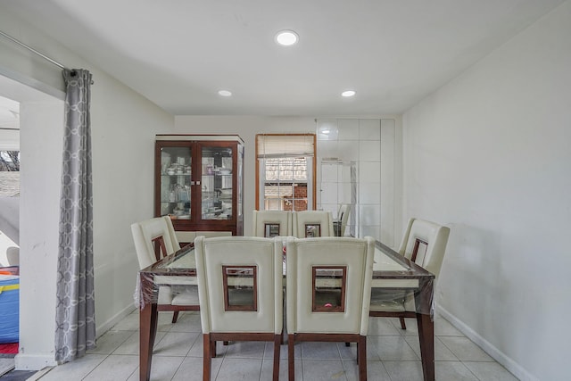 tiled dining room with recessed lighting and baseboards