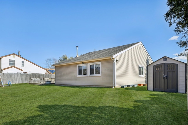 back of property featuring a storage shed, fence, a lawn, and an outdoor structure