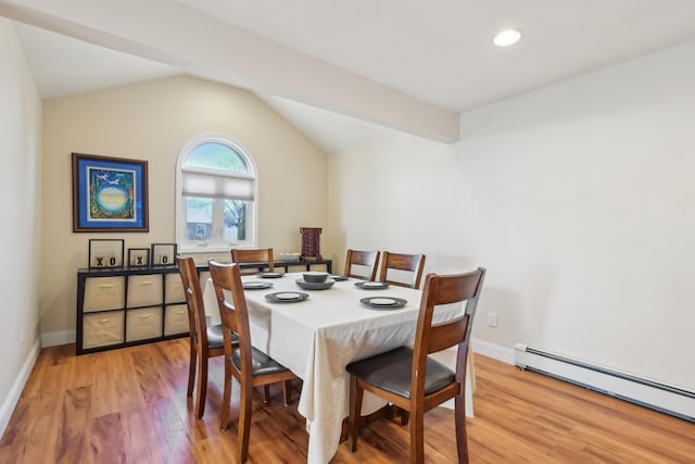 dining room featuring a baseboard radiator, baseboards, light wood-style floors, and vaulted ceiling