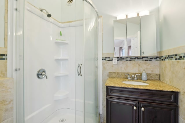 full bathroom featuring vanity, tile walls, and a stall shower