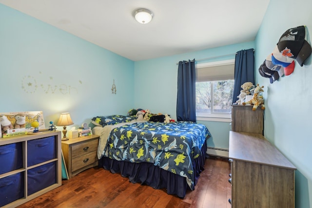 bedroom with a baseboard heating unit and dark wood-style flooring