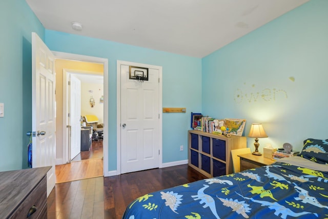 bedroom with baseboards and wood finished floors