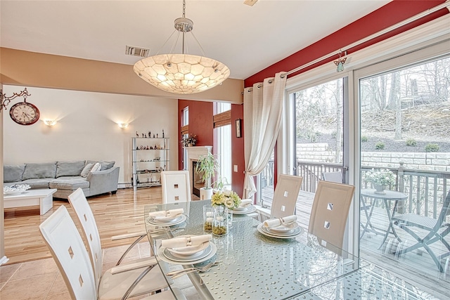 dining area featuring visible vents, lofted ceiling, and wood finished floors