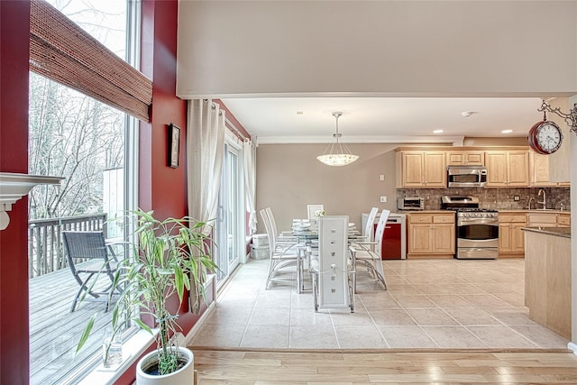 kitchen with light brown cabinets, tasteful backsplash, appliances with stainless steel finishes, and a sink