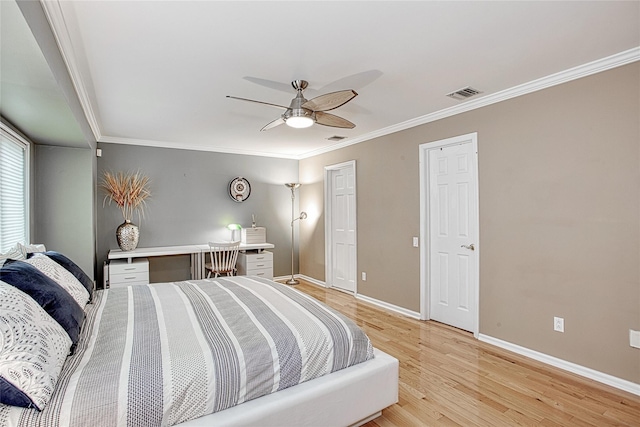 bedroom with visible vents, baseboards, crown molding, and light wood finished floors