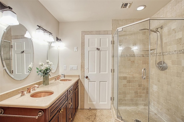 full bath with double vanity, visible vents, a stall shower, and a sink