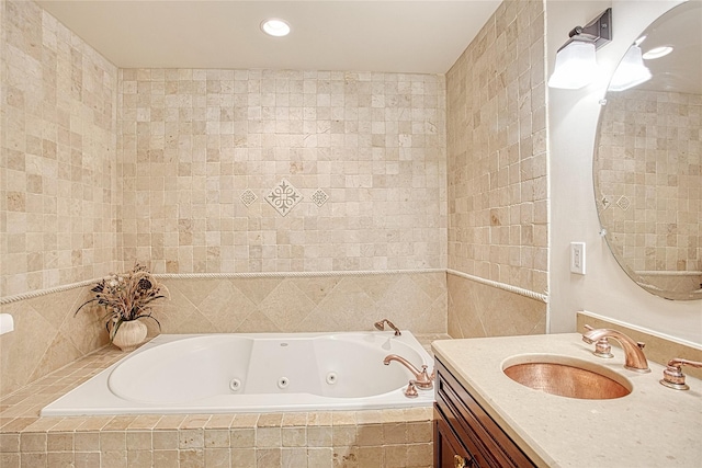 full bathroom featuring recessed lighting, tile walls, a jetted tub, and vanity