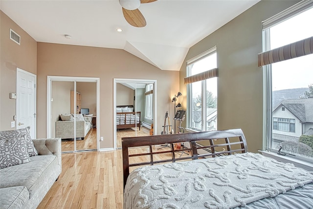 bedroom with a ceiling fan, visible vents, lofted ceiling, light wood-type flooring, and baseboard heating