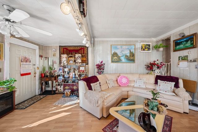 living area featuring crown molding, a ceiling fan, and wood finished floors