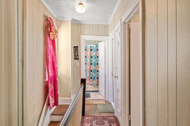 corridor featuring crown molding and wood walls