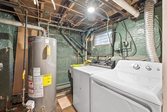 washroom featuring gas water heater, washing machine and dryer, and laundry area