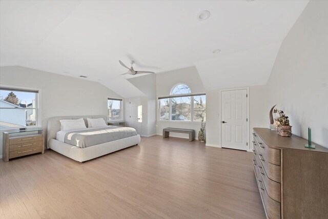 bedroom with light wood-type flooring, baseboards, a ceiling fan, and vaulted ceiling