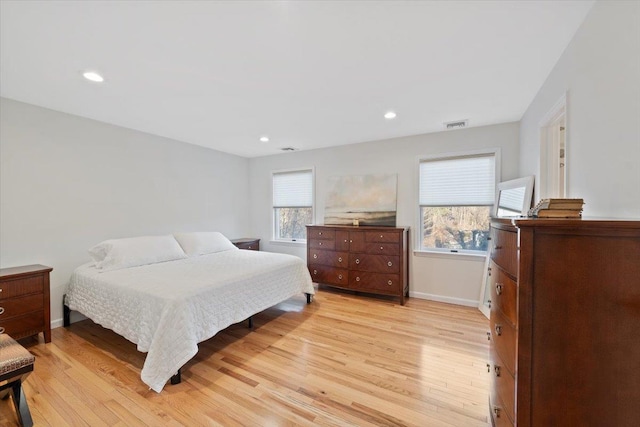 bedroom with multiple windows, baseboards, and light wood-style floors