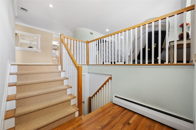 staircase with wood finished floors, visible vents, a baseboard radiator, recessed lighting, and crown molding