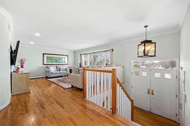 foyer entrance with light wood-type flooring, ornamental molding, recessed lighting, an inviting chandelier, and a baseboard radiator