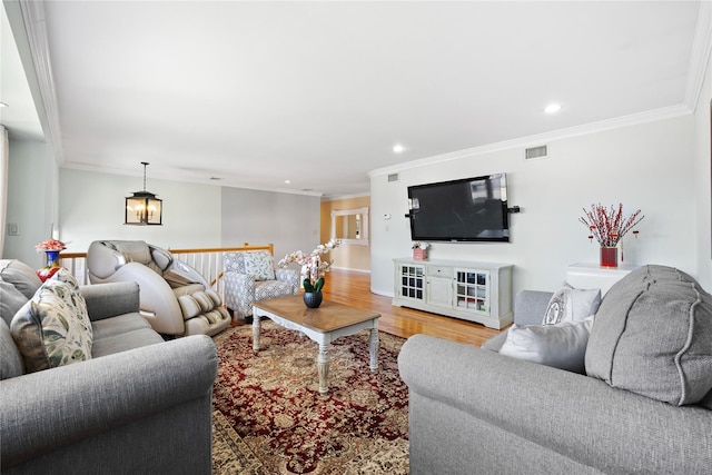 living room with recessed lighting, visible vents, wood finished floors, and crown molding