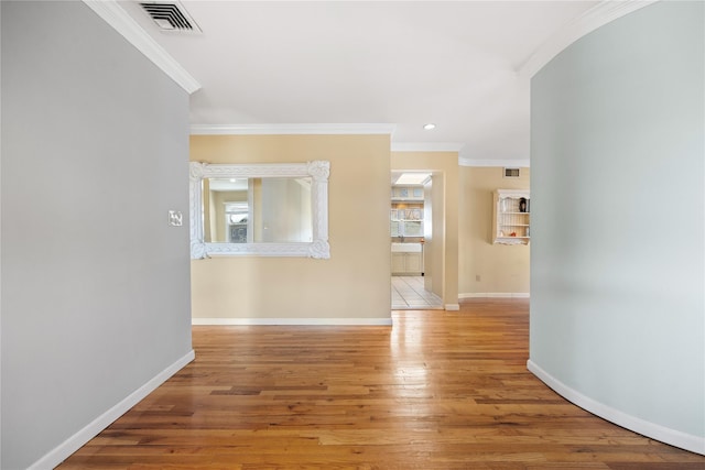 hall with plenty of natural light, baseboards, visible vents, and light wood finished floors