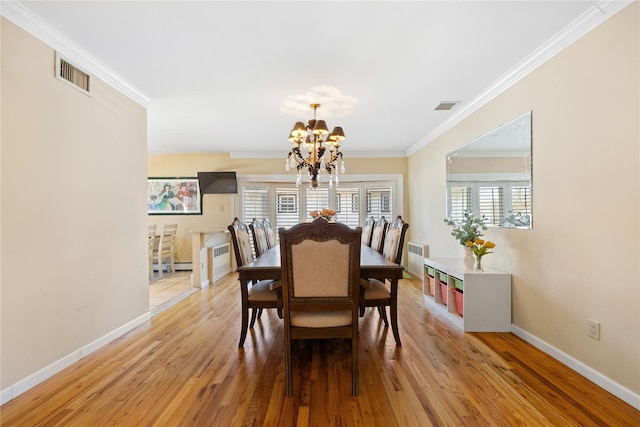 dining space with visible vents, light wood-style flooring, and ornamental molding