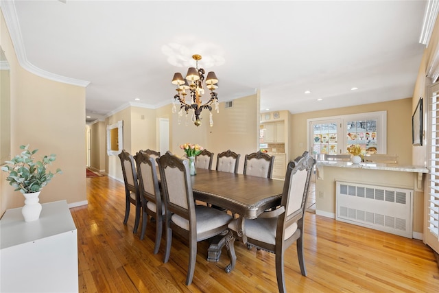 dining area featuring visible vents, radiator, ornamental molding, light wood-style flooring, and a notable chandelier