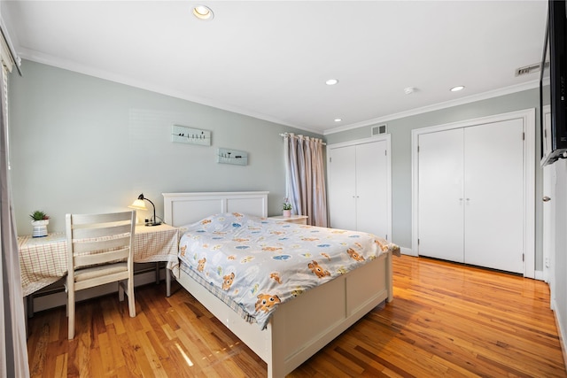 bedroom with visible vents, two closets, ornamental molding, recessed lighting, and light wood finished floors