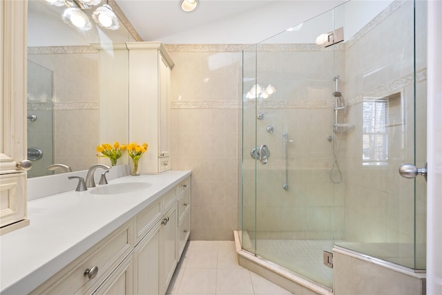 full bath with a shower stall, tile walls, lofted ceiling, tile patterned floors, and vanity