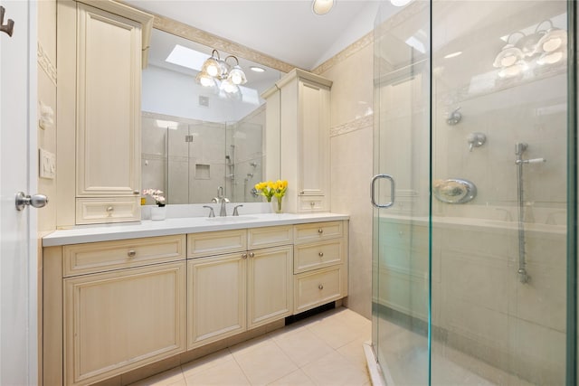 full bath with tile patterned floors, tile walls, a shower stall, vanity, and vaulted ceiling