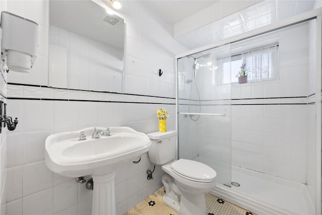 full bathroom with visible vents, a stall shower, tile patterned flooring, tile walls, and toilet