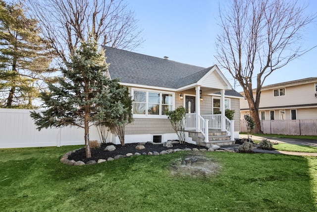 view of front of property featuring a front lawn, fence, and roof with shingles