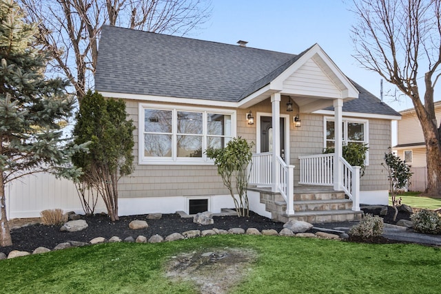 view of front facade featuring a shingled roof and a front lawn