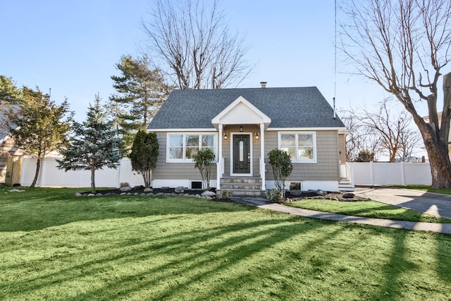 view of front facade featuring fence, entry steps, a front yard, roof with shingles, and a chimney