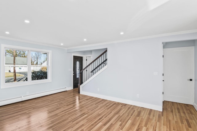 spare room with a baseboard radiator, wood finished floors, baseboards, and ornamental molding