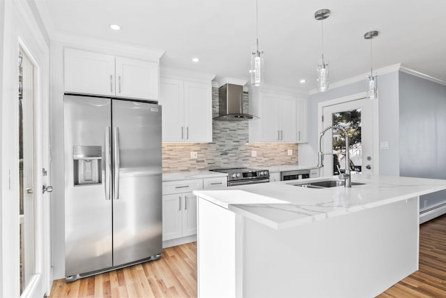 kitchen with crown molding, wall chimney range hood, a center island with sink, stainless steel appliances, and white cabinetry