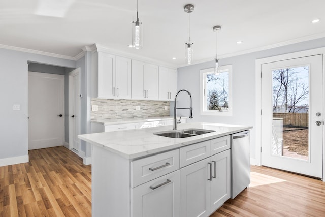 kitchen with ornamental molding, decorative backsplash, stainless steel dishwasher, white cabinets, and a sink