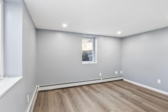 spare room with recessed lighting, wood finished floors, baseboards, and baseboard heating