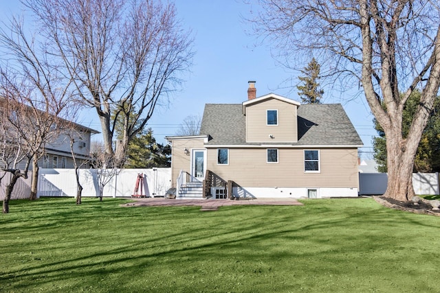 rear view of property featuring a lawn, a shingled roof, a chimney, and fence