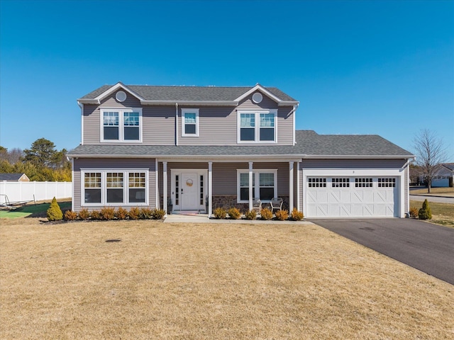 view of front of house with a front yard, an attached garage, fence, and driveway