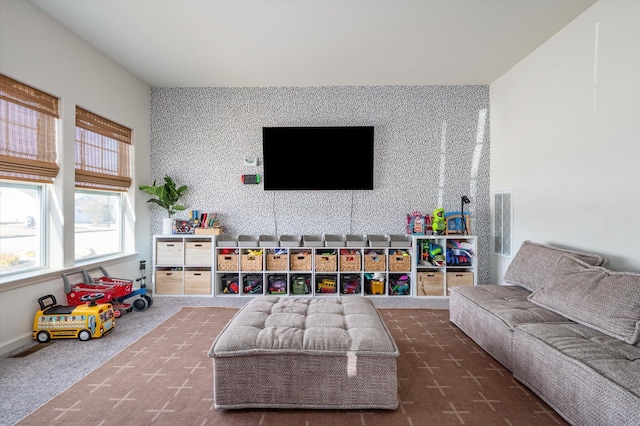 living area with visible vents, wallpapered walls, an accent wall, and carpet floors