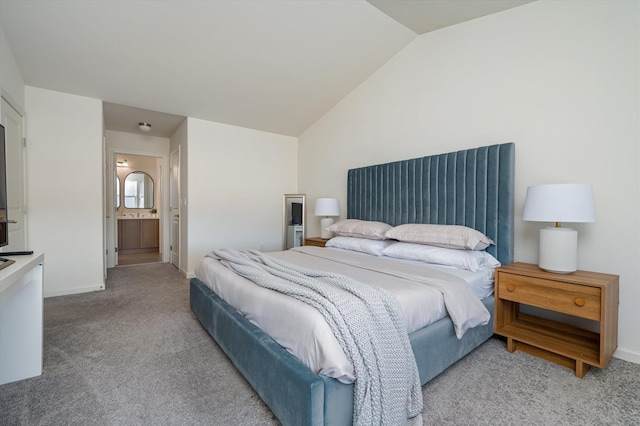 bedroom with light carpet, ensuite bathroom, baseboards, and vaulted ceiling