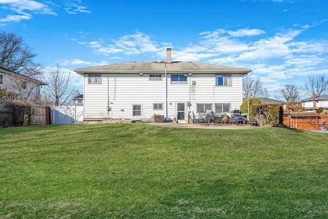 rear view of property featuring a yard, a patio, a fenced backyard, and a chimney