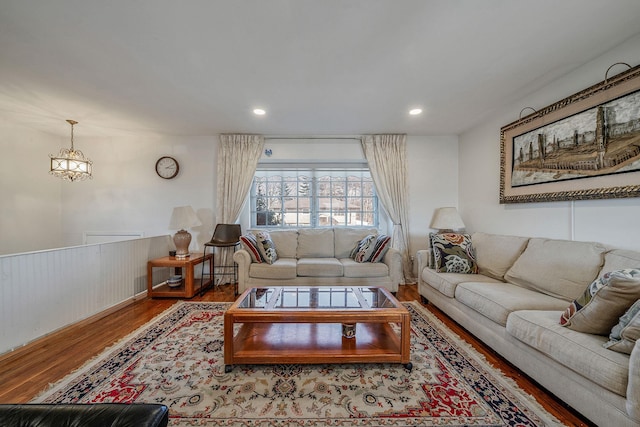 living area featuring a notable chandelier, recessed lighting, wood finished floors, and wainscoting