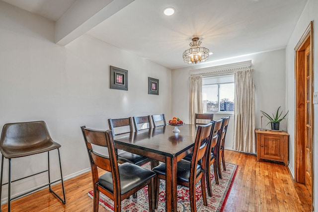 dining space featuring a notable chandelier, baseboards, and light wood-style floors