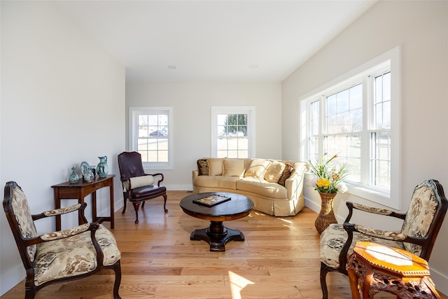 living area with light wood-type flooring and baseboards