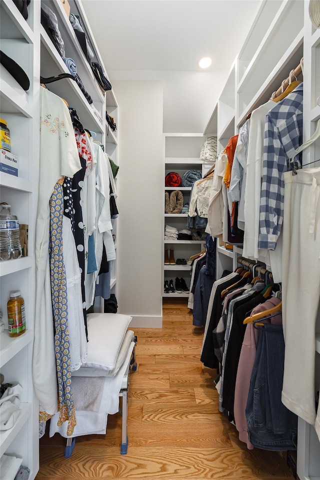 walk in closet with light wood finished floors