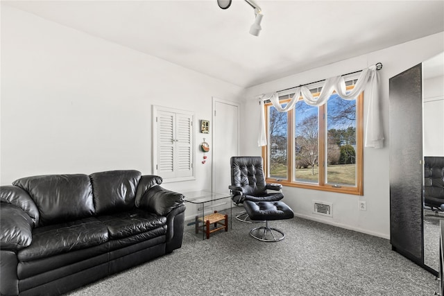 carpeted living room featuring visible vents, baseboards, and track lighting