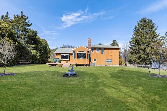 back of house featuring central AC, a lawn, a chimney, and a deck