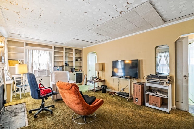 carpeted office space with built in shelves, arched walkways, baseboards, and ornamental molding