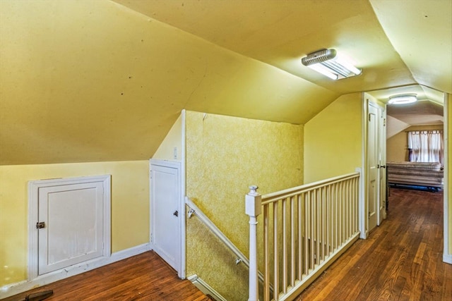 additional living space featuring baseboards, lofted ceiling, and wood finished floors