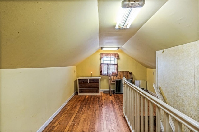 additional living space featuring vaulted ceiling, wood finished floors, and baseboards